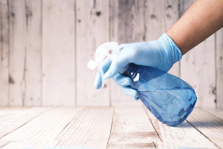 Commercial cleaning professional applying disinfectant to office surfaces