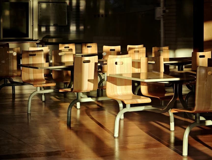Clean commercial cafeteria with sanitized tables, mopped floors, and organized service stations