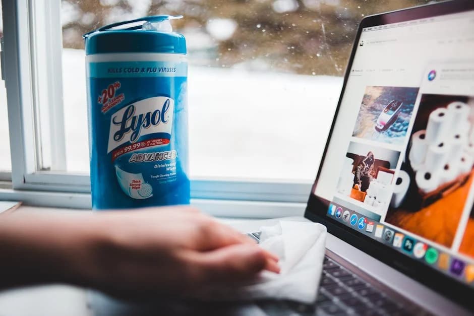 Office cleaning professional disinfecting workstation surfaces with commercial products