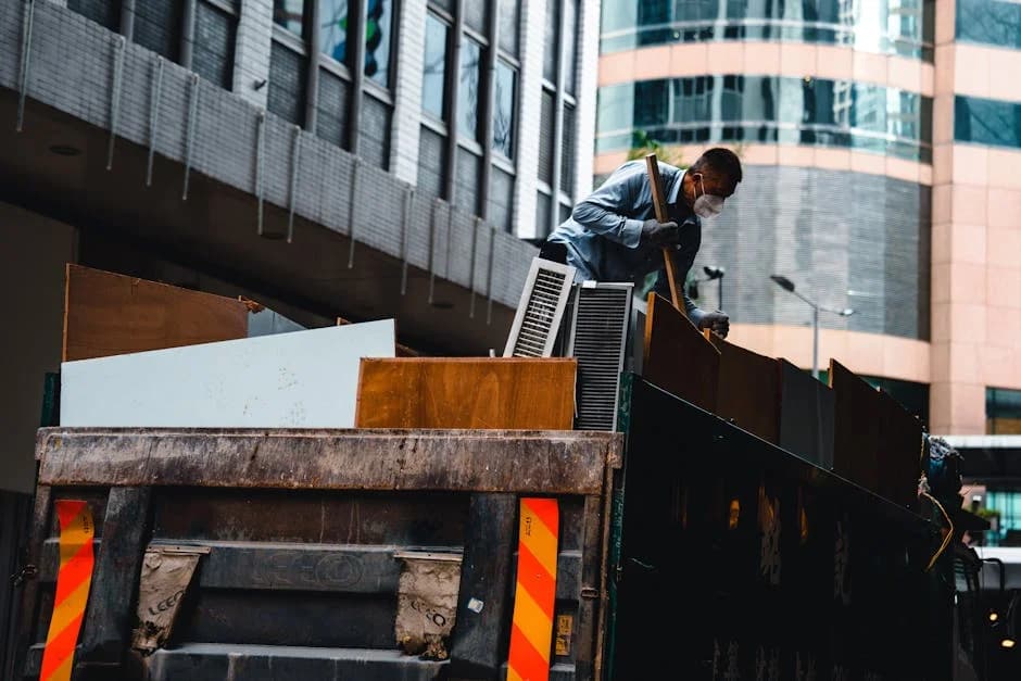 Construction site cleaning crew in proper PPE clearing debris safely